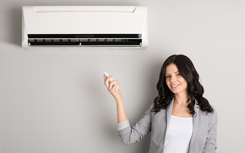 woman turning on ductless mini-split