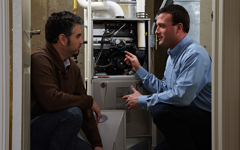 heating technician talking to homeowner